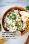 A bowl of almost classic cottage cheese chicken salad topped with green onions and served with toasted bread slices, with text overlay describing the dish.