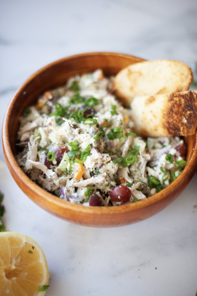 Cottage cheese chicken salad in wood bowl with toasted bread on the side.
