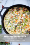 A cast iron skillet with a baked egg dish topped with herbs and cheese sits on a marble surface. Text overlay reads: Macro-Friendly Mother’s Day Brunch Ideas www.lillieeatsandtells.com—perfect inspiration for healthy, delicious Mother’s Day celebrations.