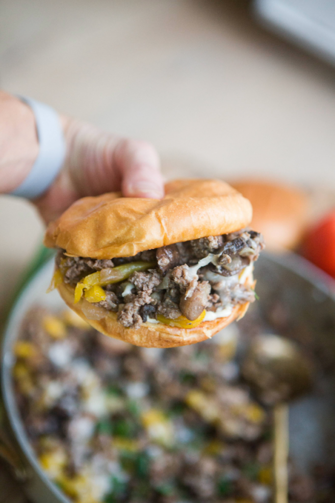 Philly Skillet stuffed in a hamburger bun with skillet below the sandwich.