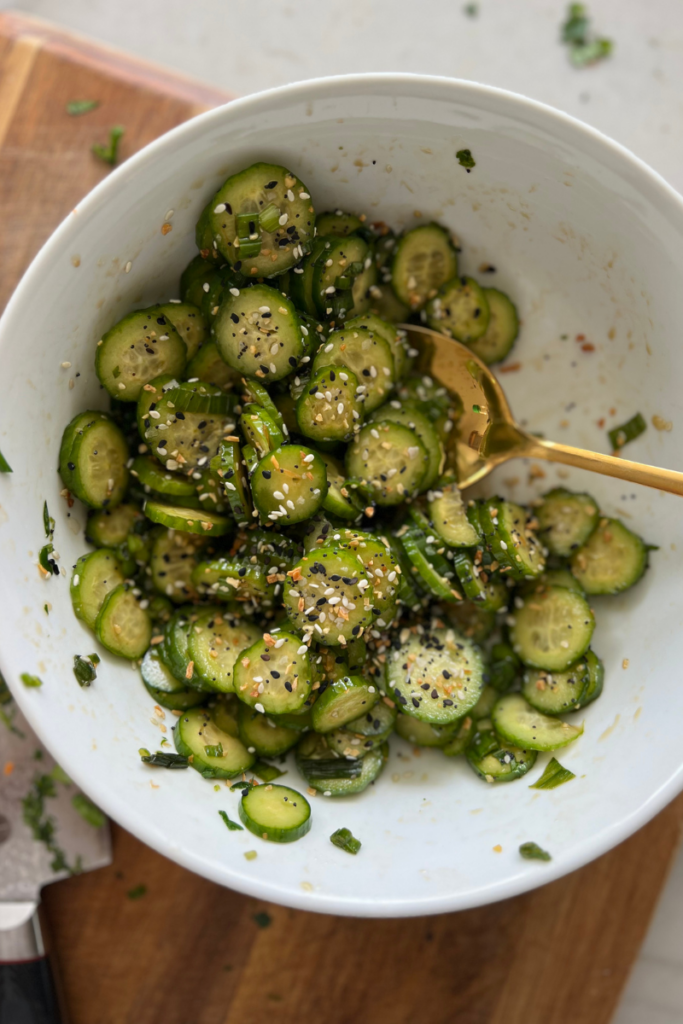 Spoon picking up cucumber salad with sesame seeds