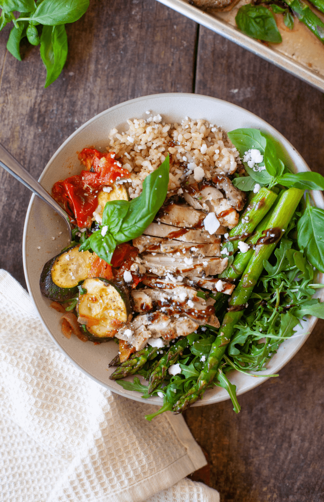 Air fryer asparagus in a bowl with chicken and vegetables.