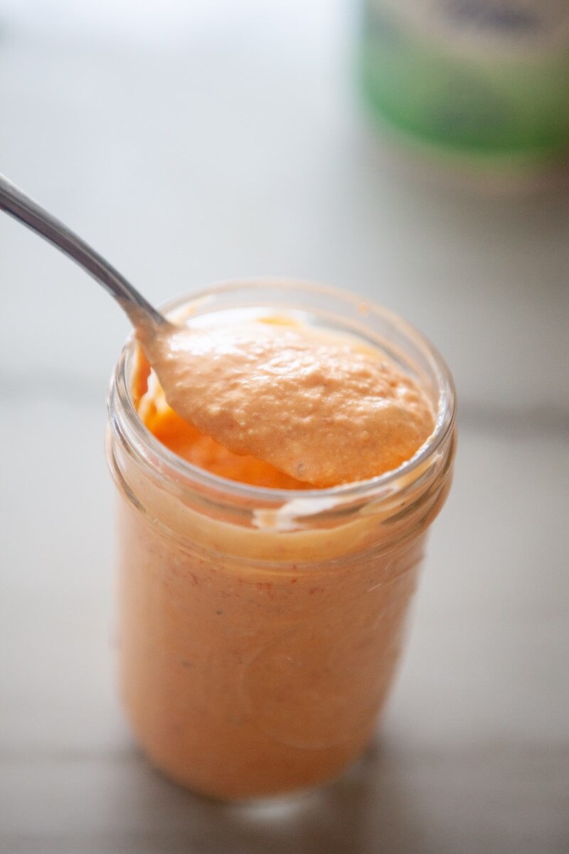 Red pepper feta sauce in a glass mason jar.