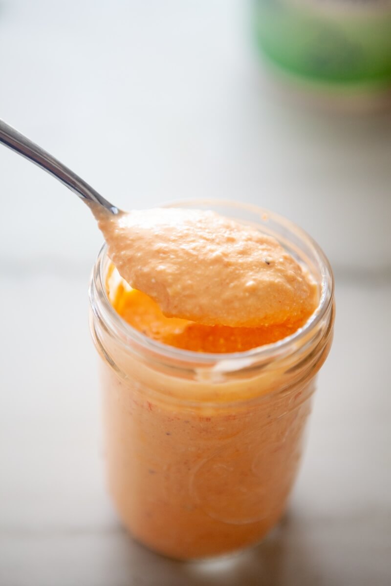 Scoop of feat spread being taken out of a jar.
