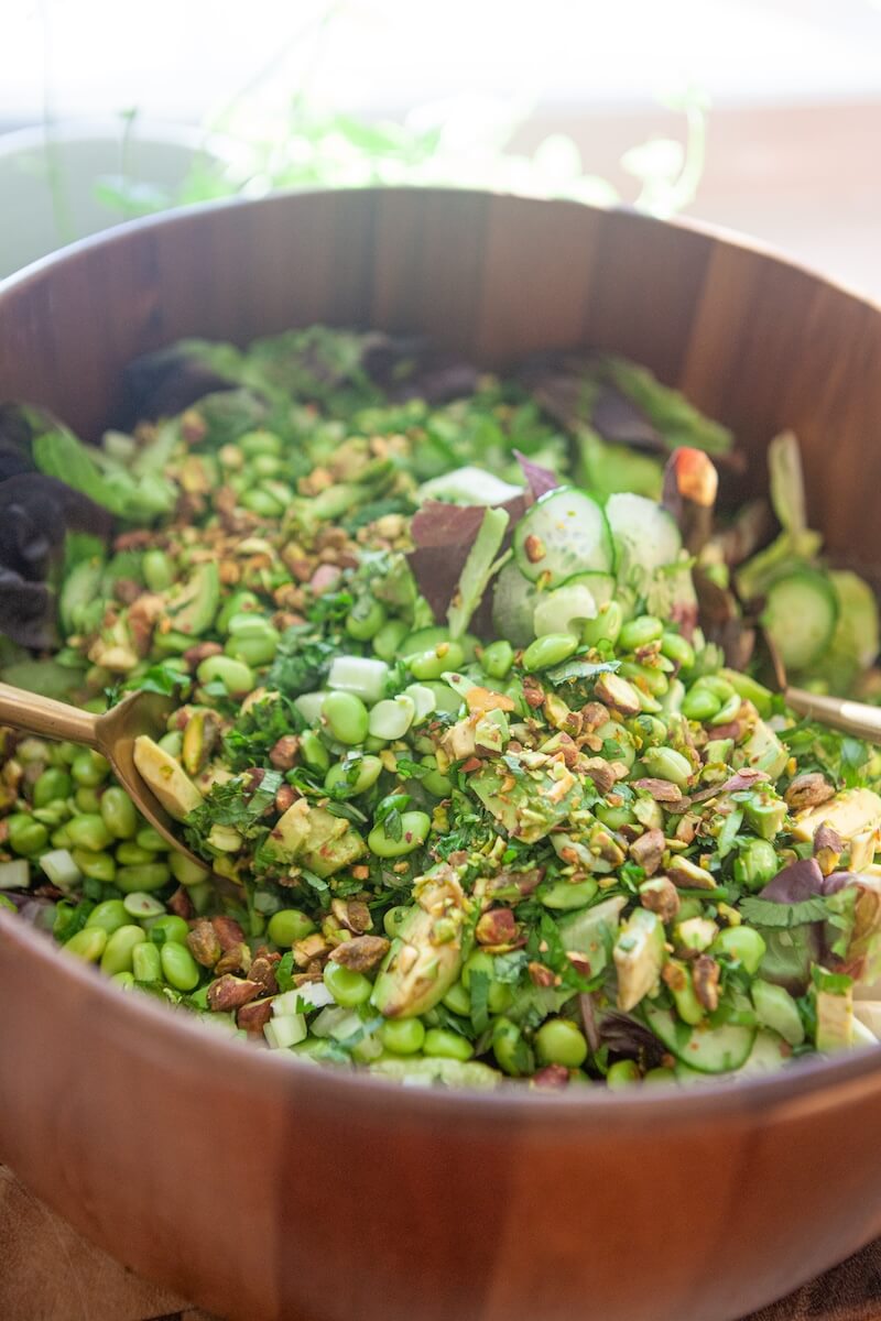 Close up of ingredients being mixed to make a super green salad.
