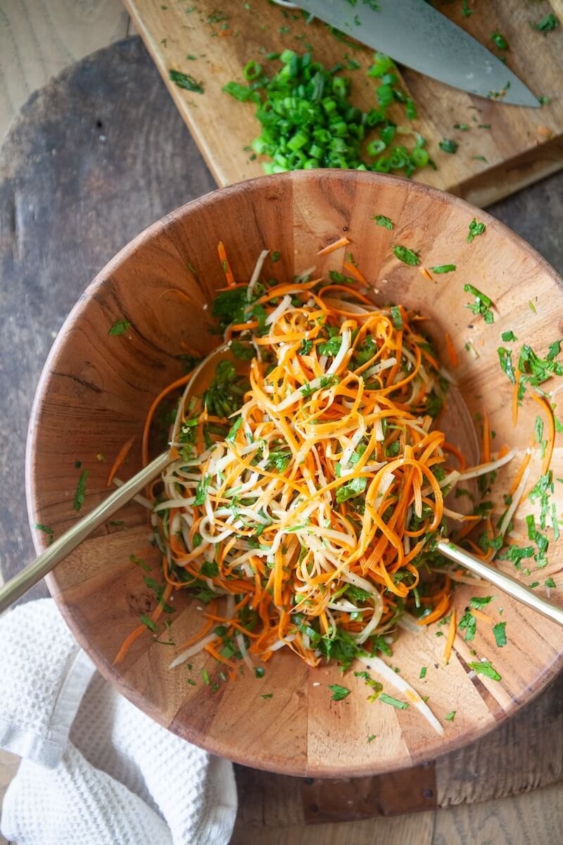 Carrot slaw in a large wooden bowl.