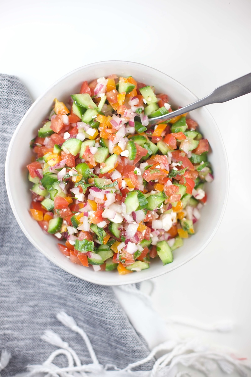 Chopped veggies for cucumber salsa in a white bowl.
