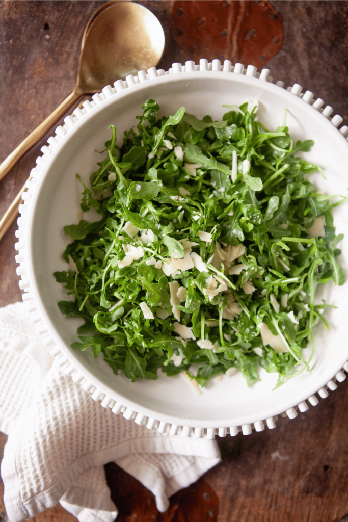 Simple arugula salad topped with parmesan cheese.