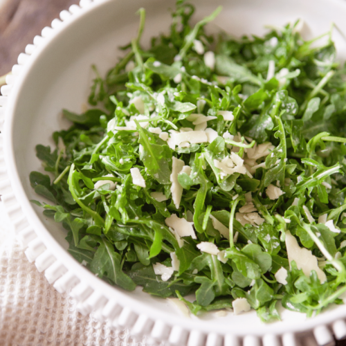 Green arugula salad tossed in olive oil.