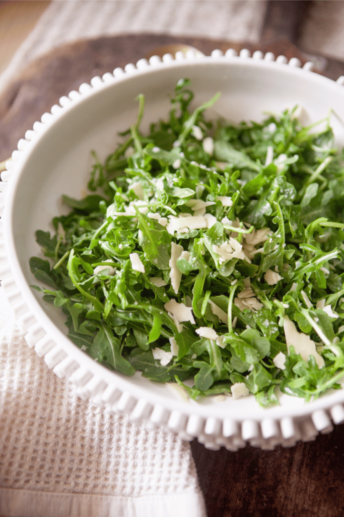 Green arugula salad tossed in olive oil.