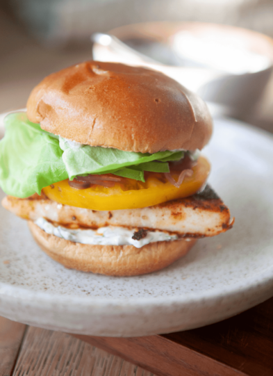 Blackened fish sandwich on a white serving plate.