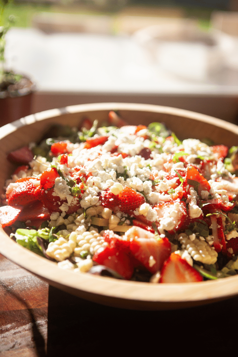 Fresh strawberry summer salad topped with crumbled feta cheese.