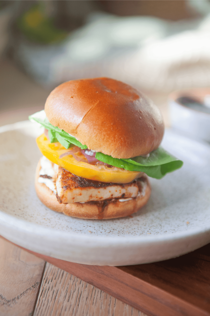 Blackened fish sandwich assembled with heirloom tomatoes and butter lettuce.