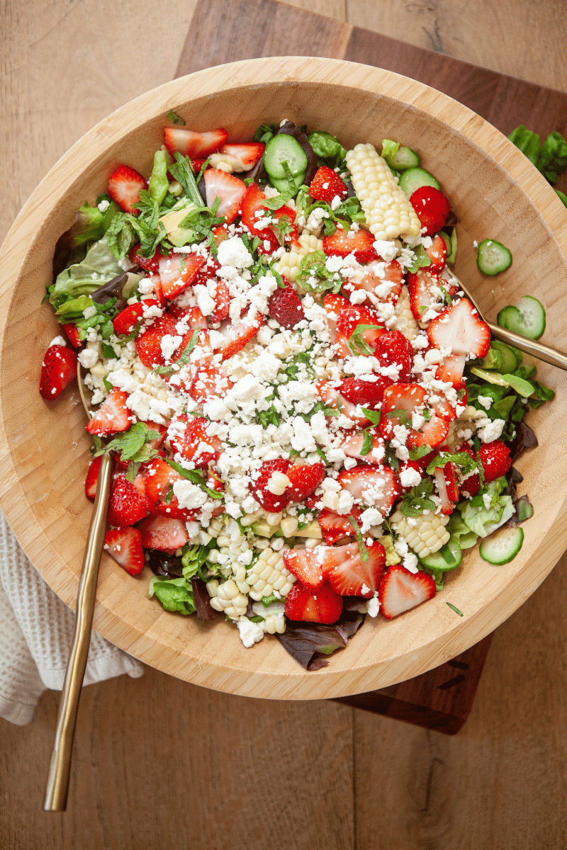 Summer strawberry salad in a wooden bowl.