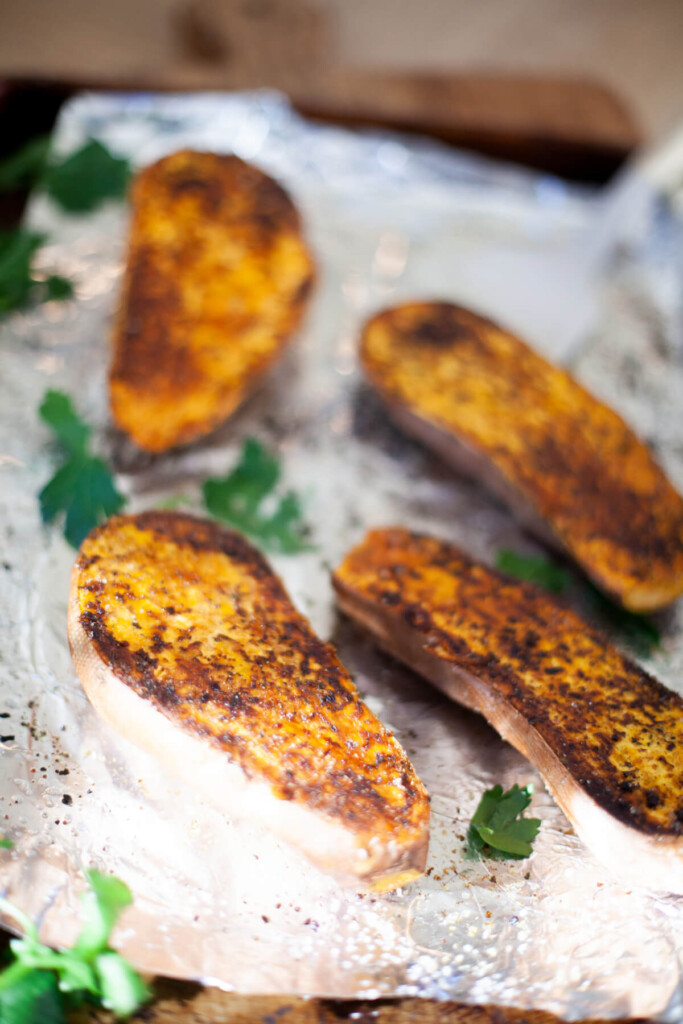 Sweet potato halves roasted on a sheet pan.