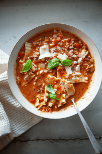 Bowl of no noodle lasagna soup with white napkin.