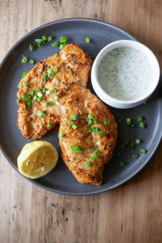 Yogurt marinated air fryer chicken on a dark gray plate.