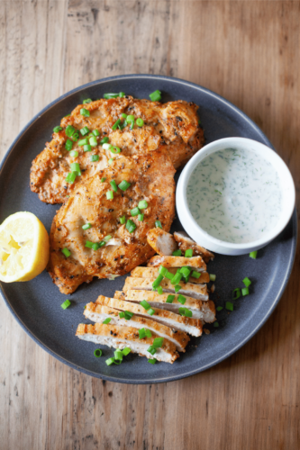 Large gray plate with yogurt marinated air fryer chicken.