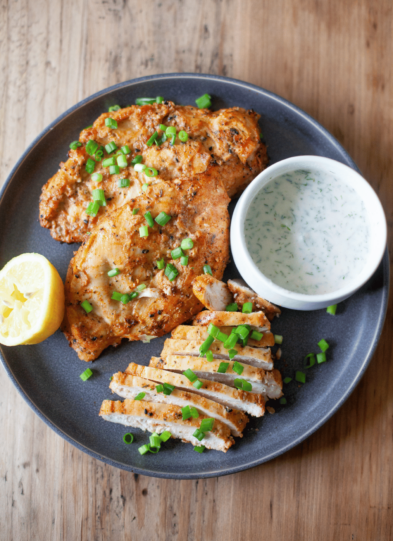 Large gray plate with yogurt marinated air fryer chicken.