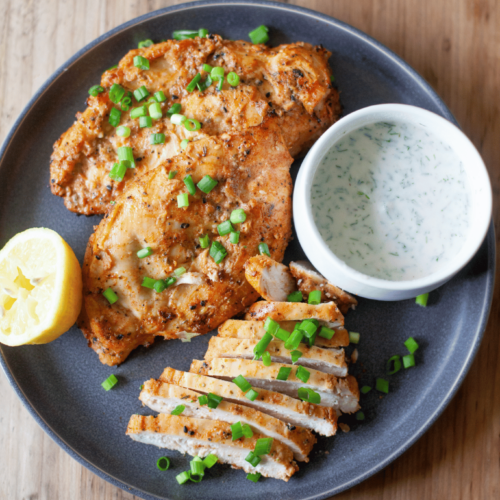 Large gray plate with yogurt marinated air fryer chicken.