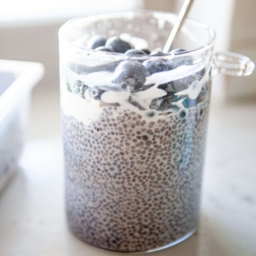 Blueberry chia pudding in glass jar with spoon.