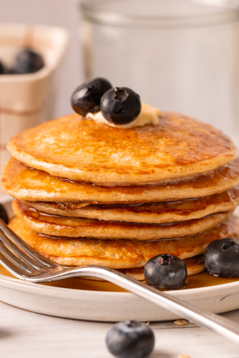 Stack of cottage cheese pancakes on plate with fork.