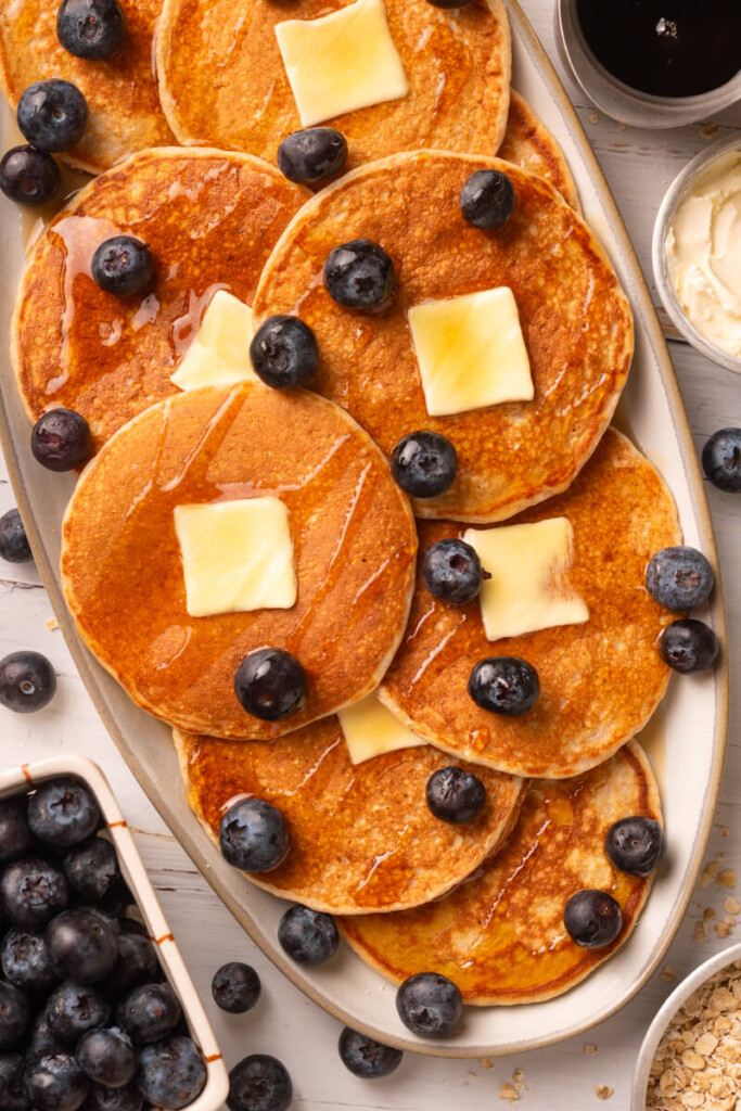 Plate of cottage cheese pancakes with butter and blueberries.