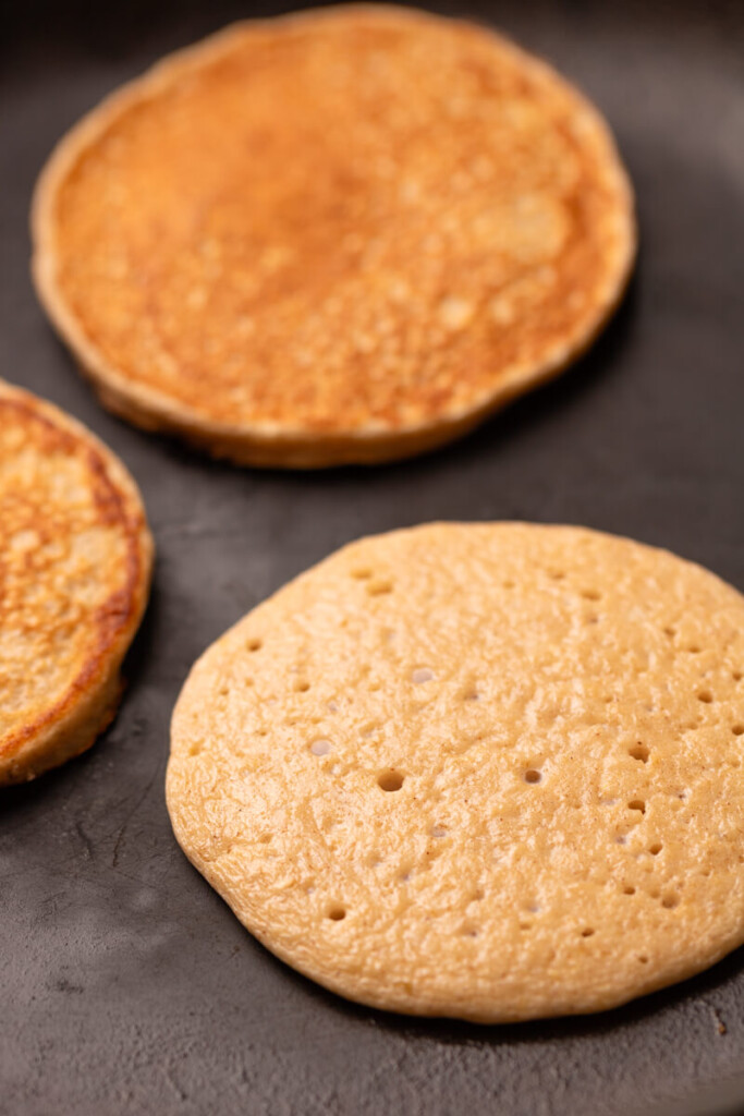 Cottage cheese pancakes cooking on hot griddle.