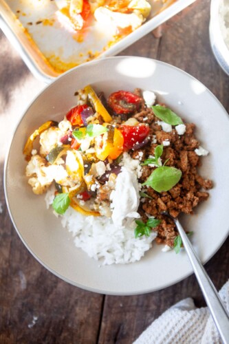 Veggie rice bowl with toppings in serving bowl with fork.
