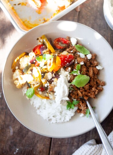 Veggie rice bowl with toppings in serving bowl with fork.