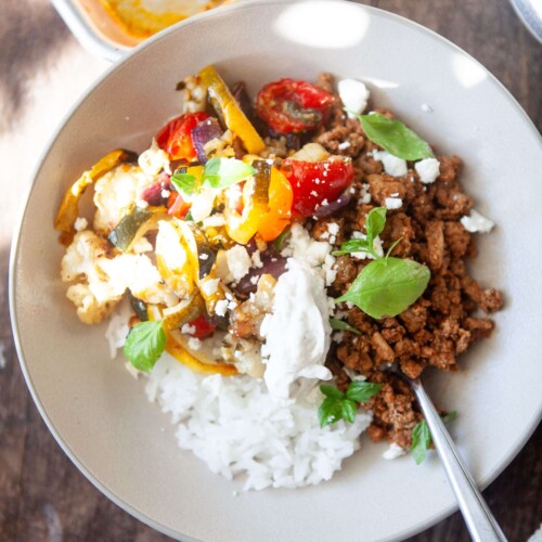 Veggie rice bowl with toppings in serving bowl with fork.