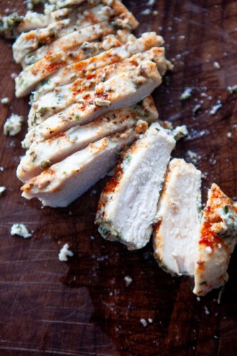 Cut up baked yogurt and herb chicken breasts on cutting board.