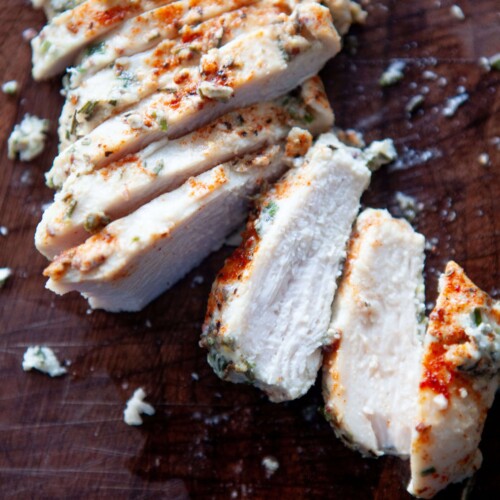 Cut up baked yogurt and herb chicken breasts on cutting board.