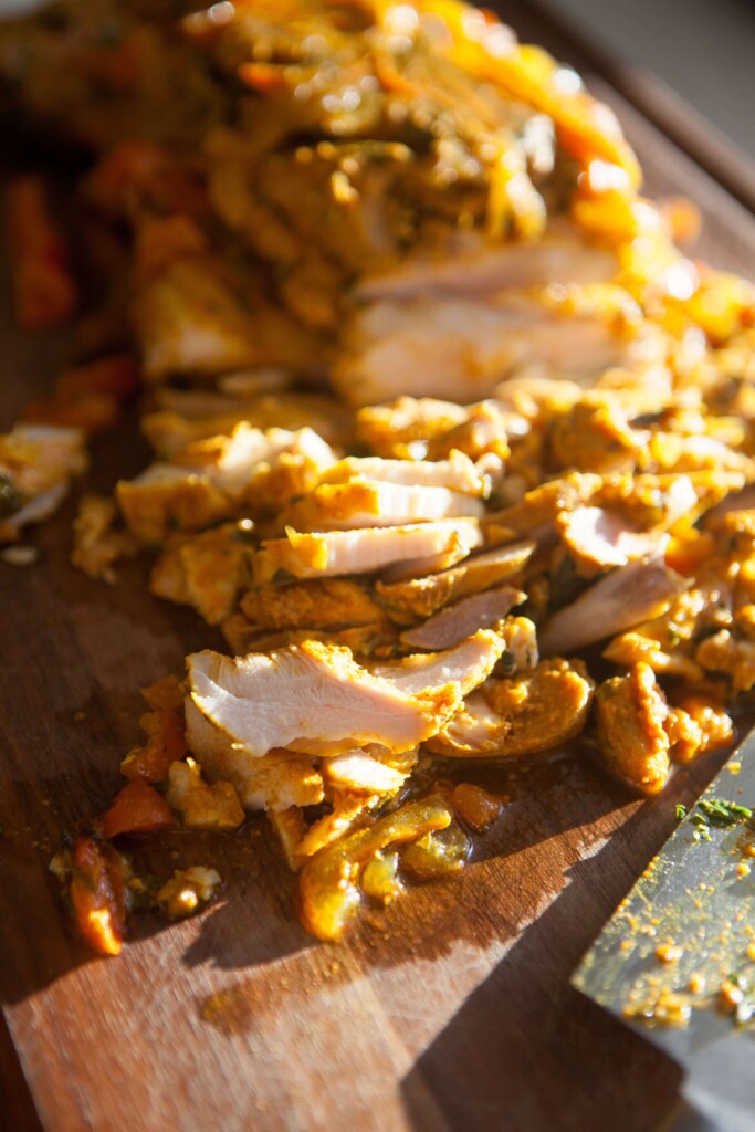 chicken shawarma on cut up on cutting board.