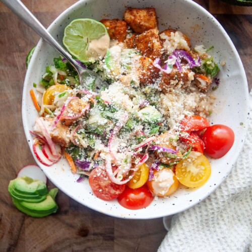 Fish taco bowl sprinkled with cotija cheese.
