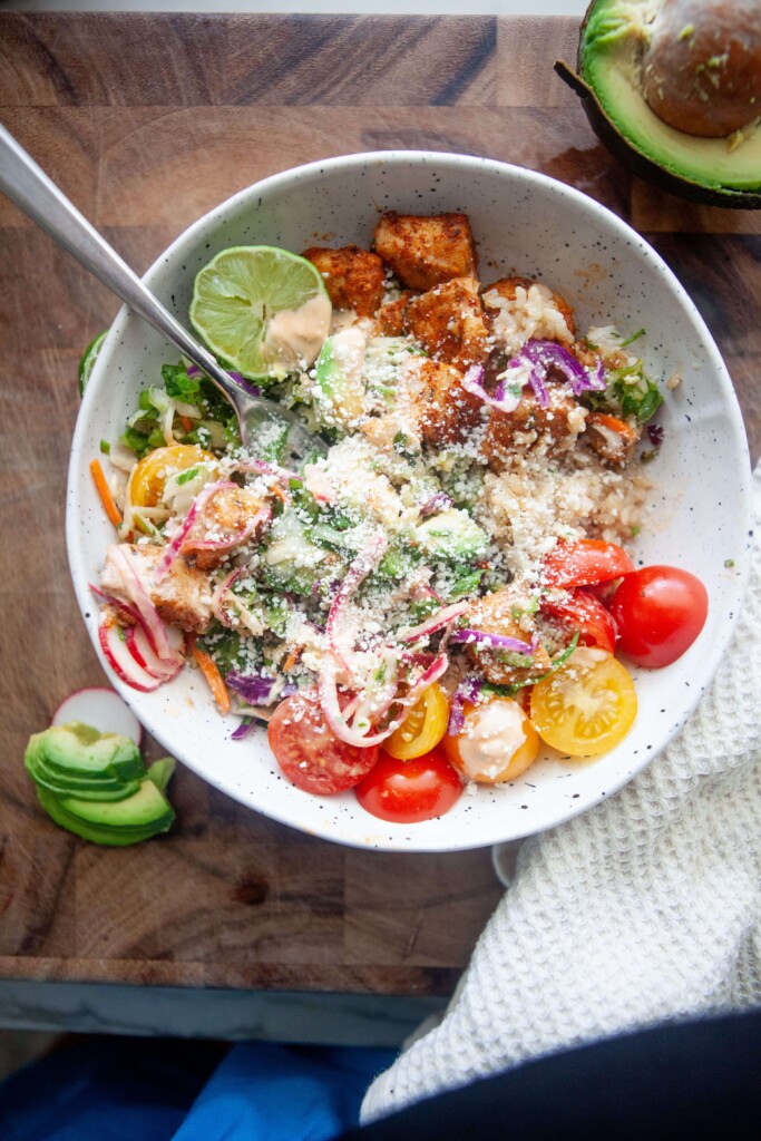 Fish taco bowl sprinkled with cotija cheese.