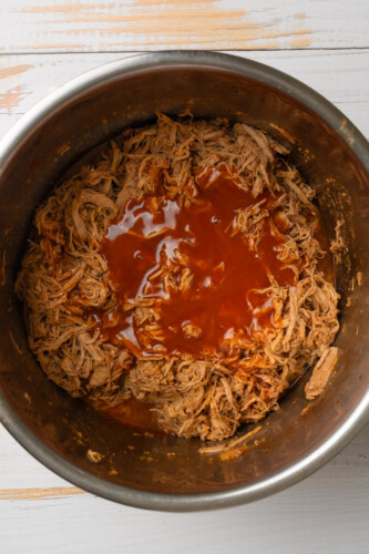 Enchilada sauce on top of shredded pork tenderloin in instant pot.