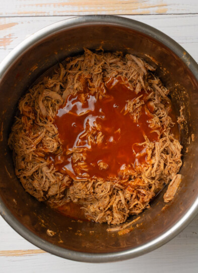 Enchilada sauce on top of shredded pork tenderloin in instant pot.