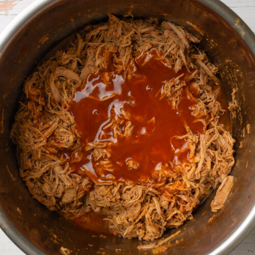 Enchilada sauce on top of shredded pork tenderloin in instant pot.