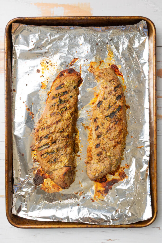 Cooked rosemary pork tenderloins on baking sheet lined with tin foil.