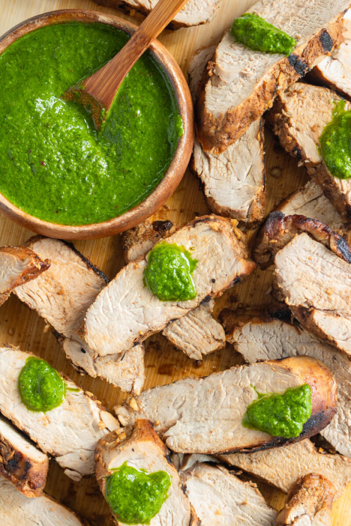 Cilantro basil chimichurri on top of sliced brown sugar spiced tenderloin