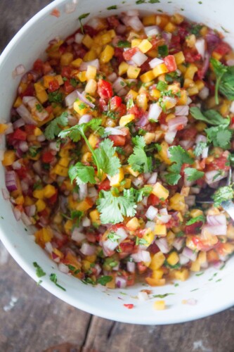 Mango salsa in bowl garnished with cilantro.
