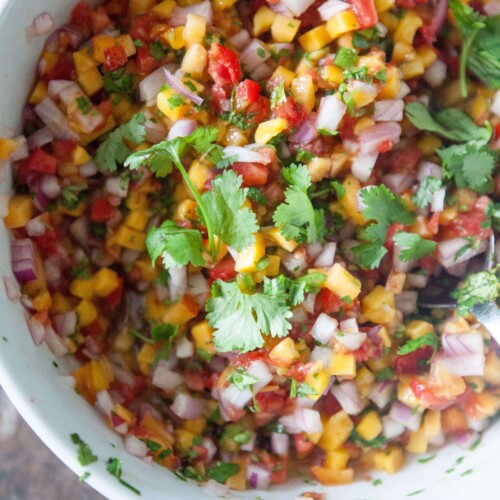 Mango salsa in bowl garnished with cilantro.