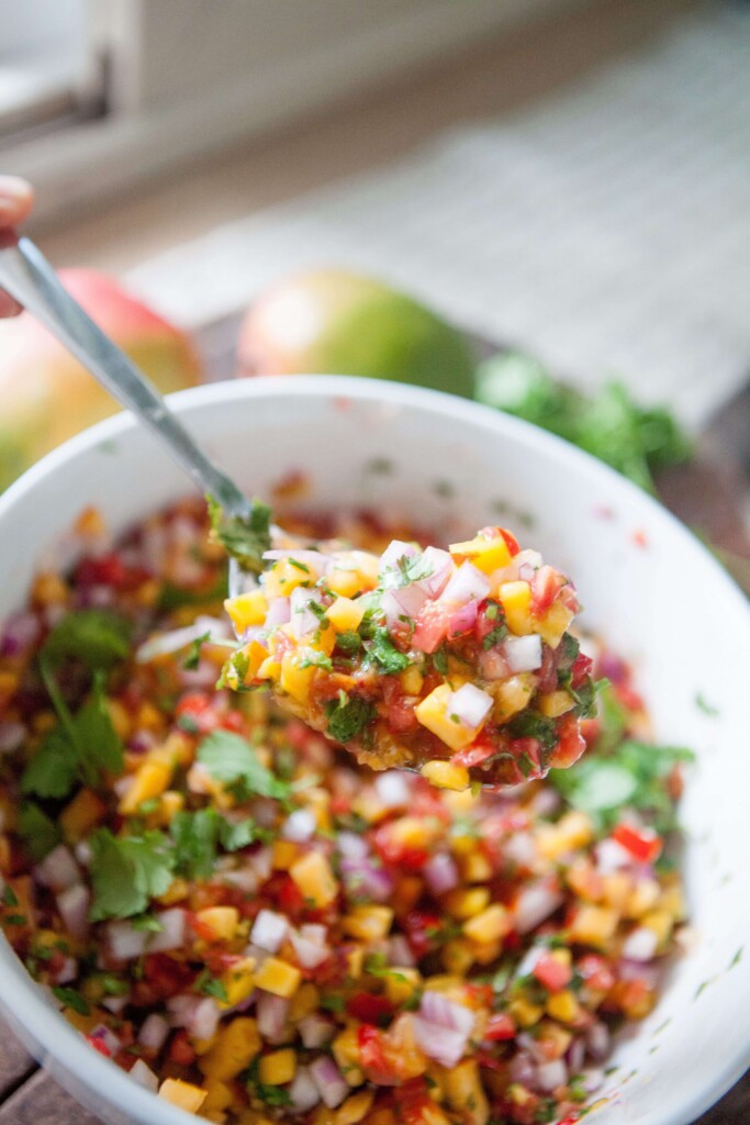 Fresh mango salsa on spoon.