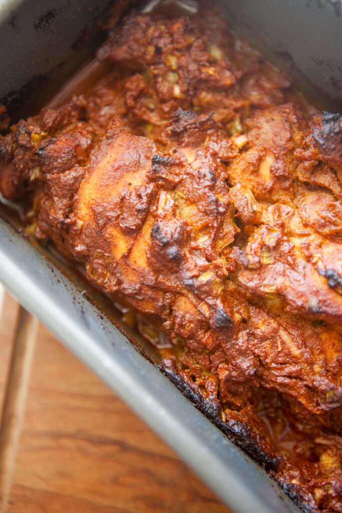Stacked mexican chicken thighs cooked in a loaf pan.