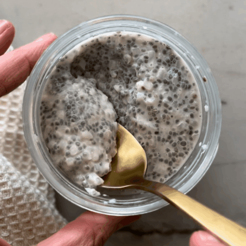 Cauliflower chia pudding mixed together in glass jar with gold spoon.