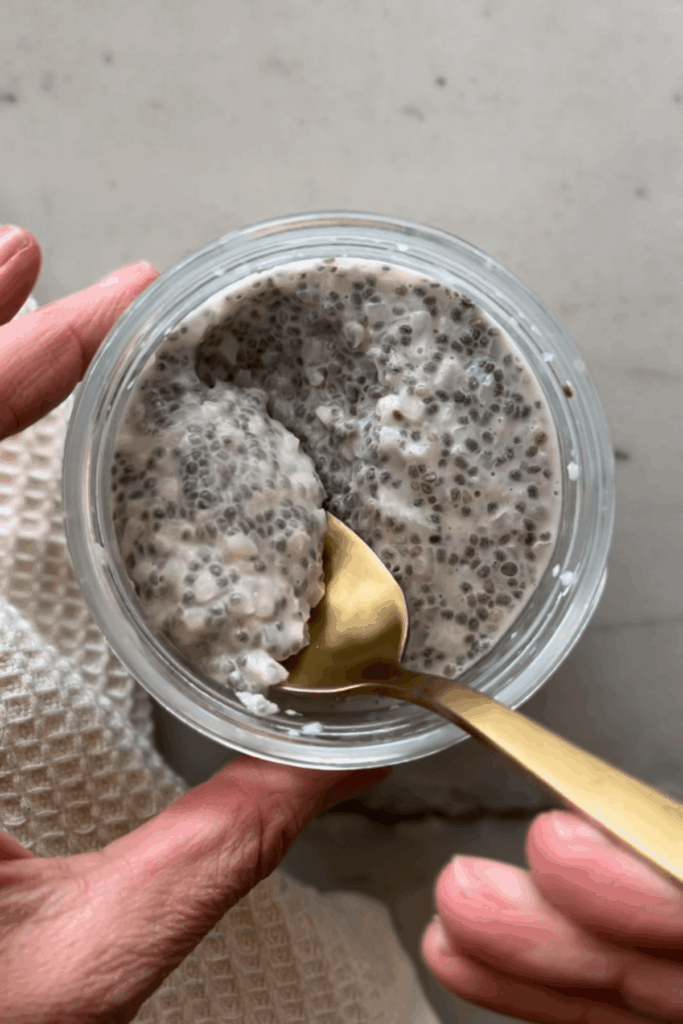 Cauliflower chia pudding mixed together in glass jar with gold spoon.