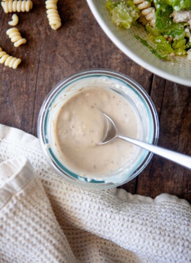 Greek yogurt caesar dressing in small glass bowl with spoon.