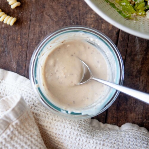 Greek yogurt caesar dressing in small glass bowl with spoon.