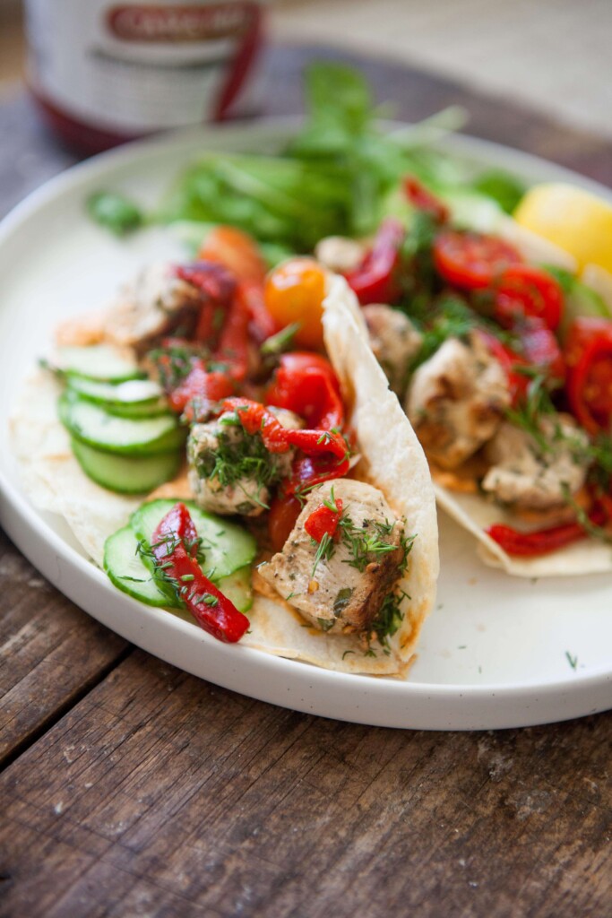 Harissa feta chicken wraps on white plate.
